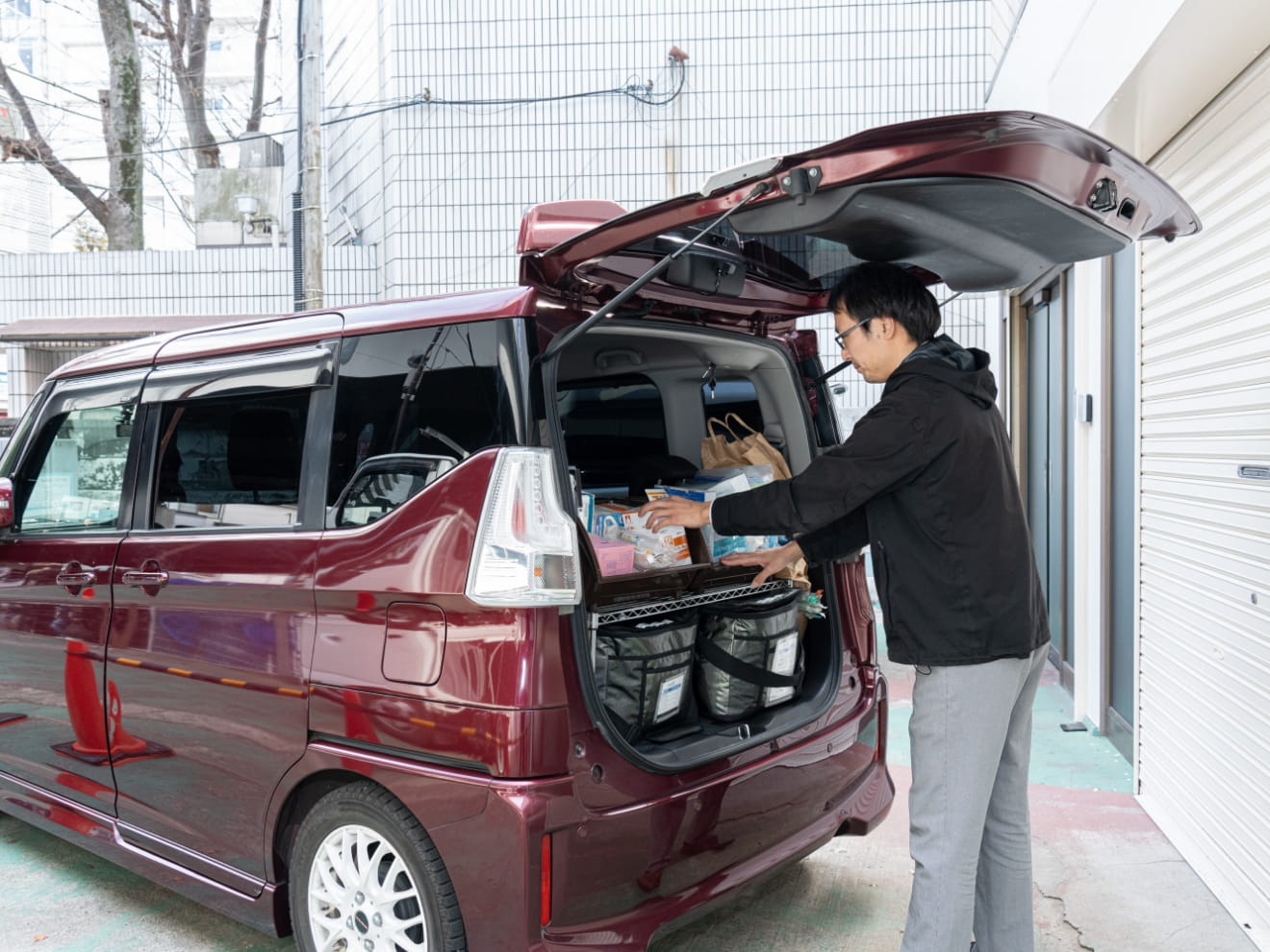 訪問準備のため車の荷台を整理するスタッフ