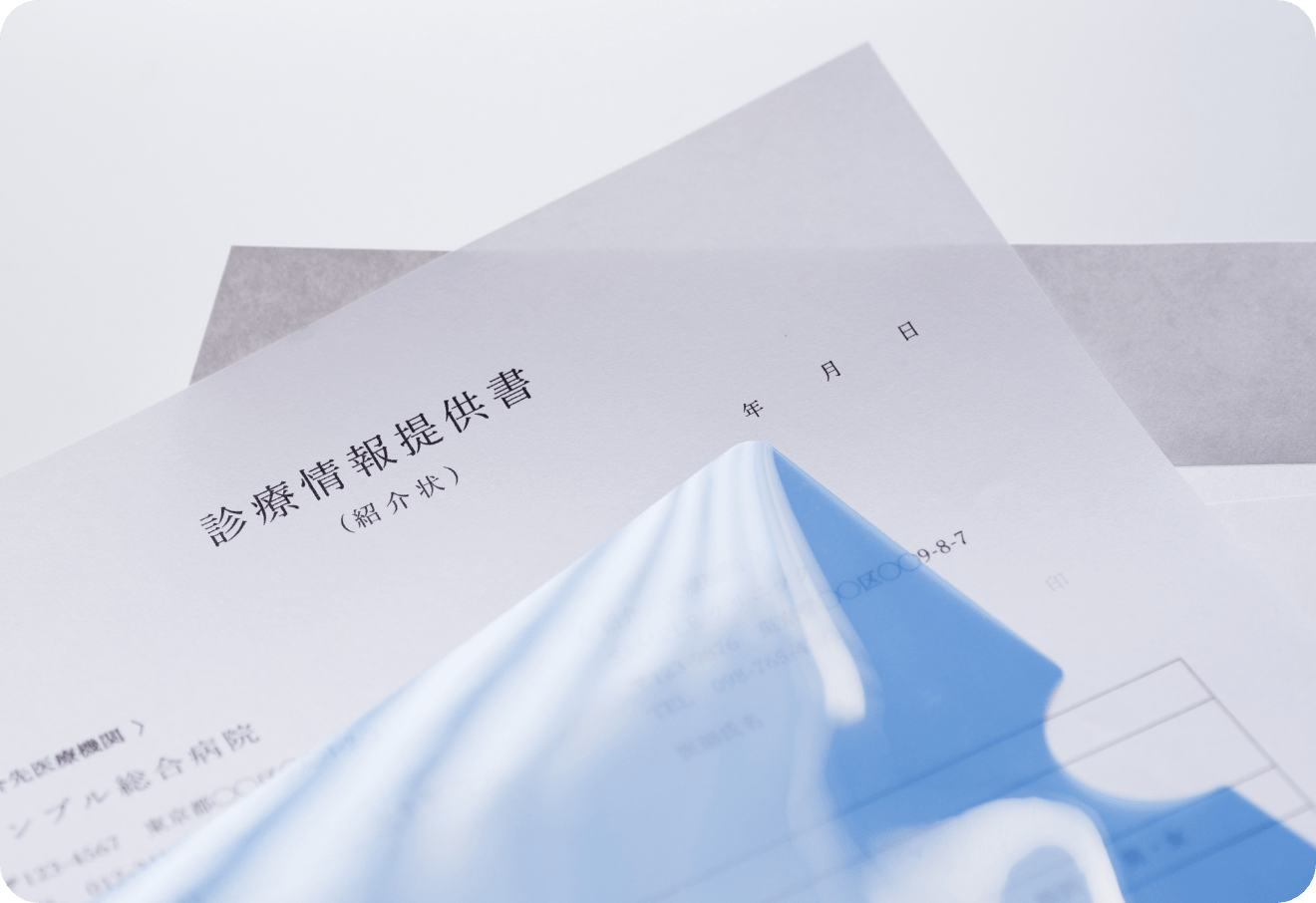 診療情報提供書（紹介状）と青色のクリアファイルのクローズアップ写