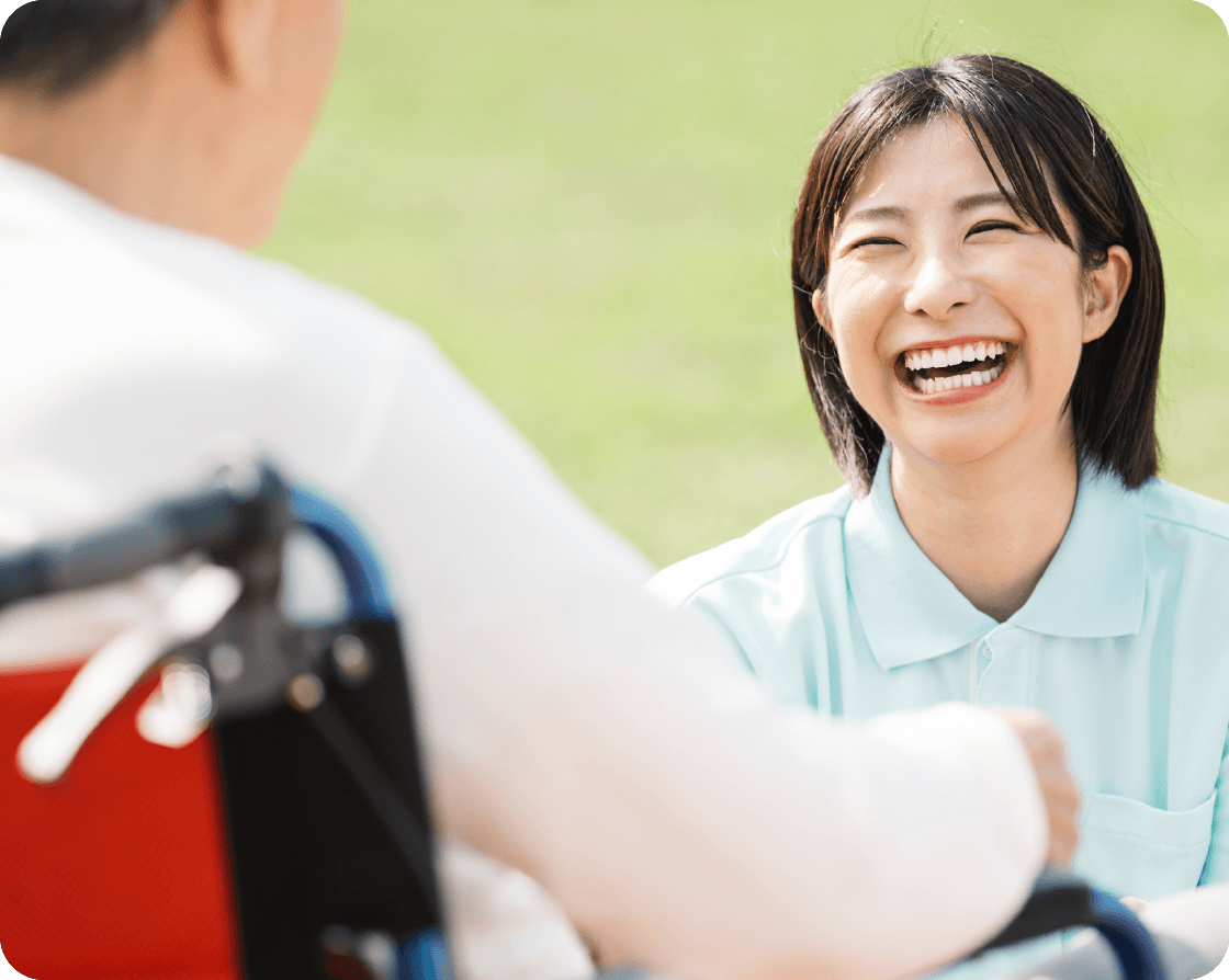 利用者と向き合いながら微笑む訪問スタッフ