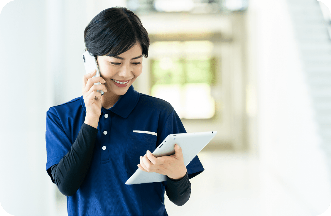 ヘッドセットをつけ、電話とパソコンでサービス調整を行う女性スタッフ。